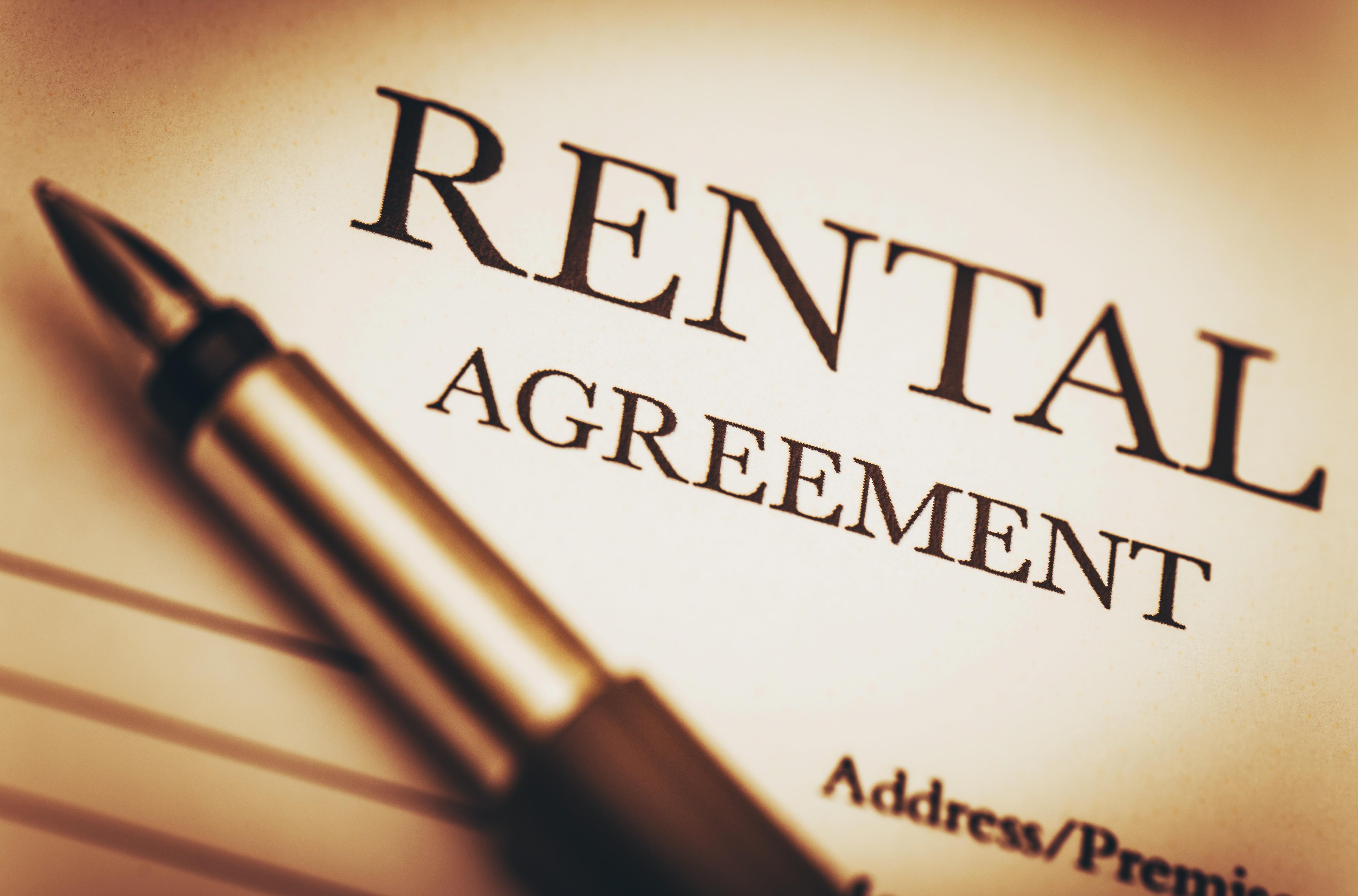 image of pen and paper with rental agreement typed on it