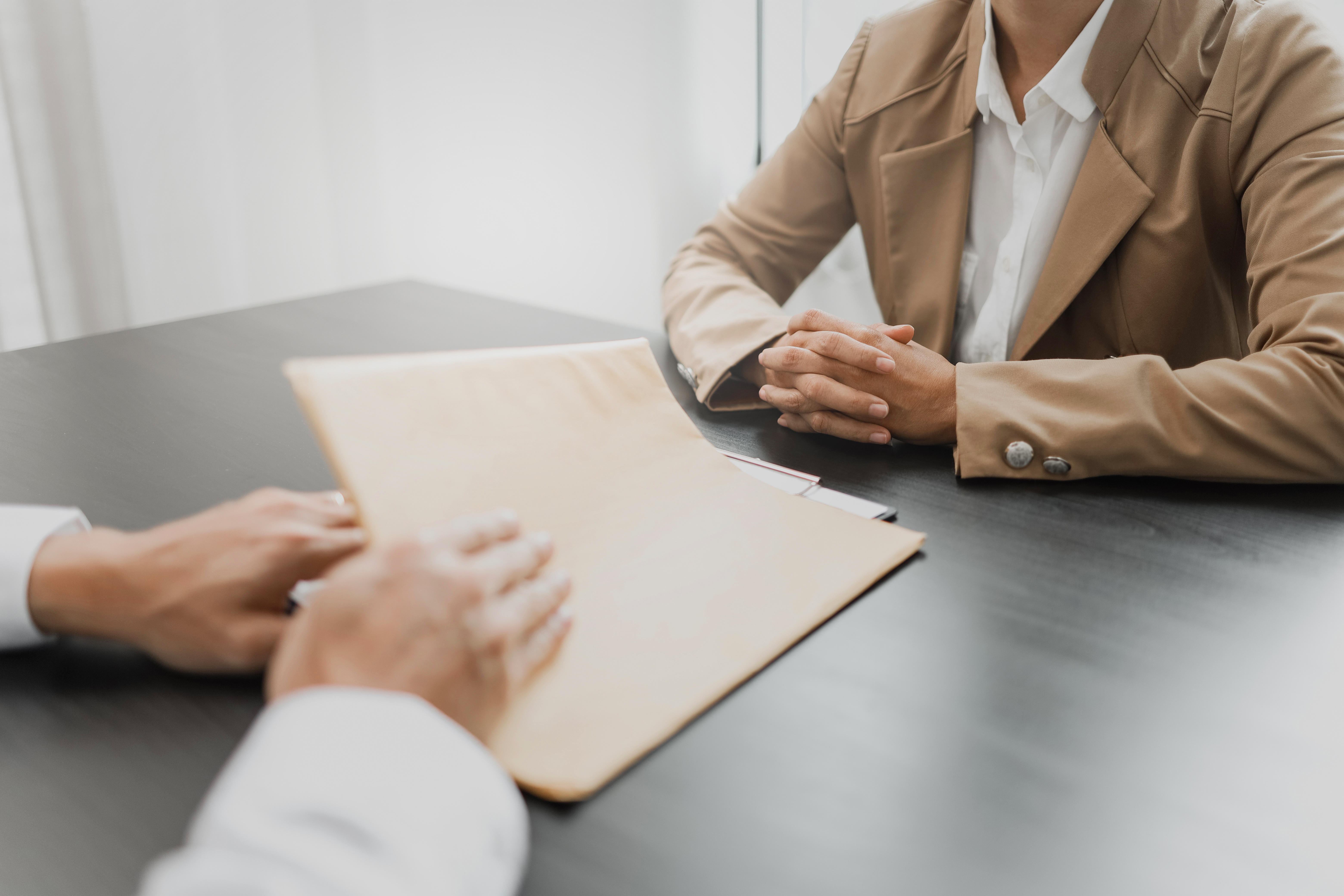 Attorney and client speaking over documents on a desk