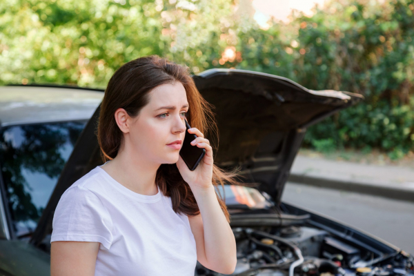 Person on phone in front of wreaked car